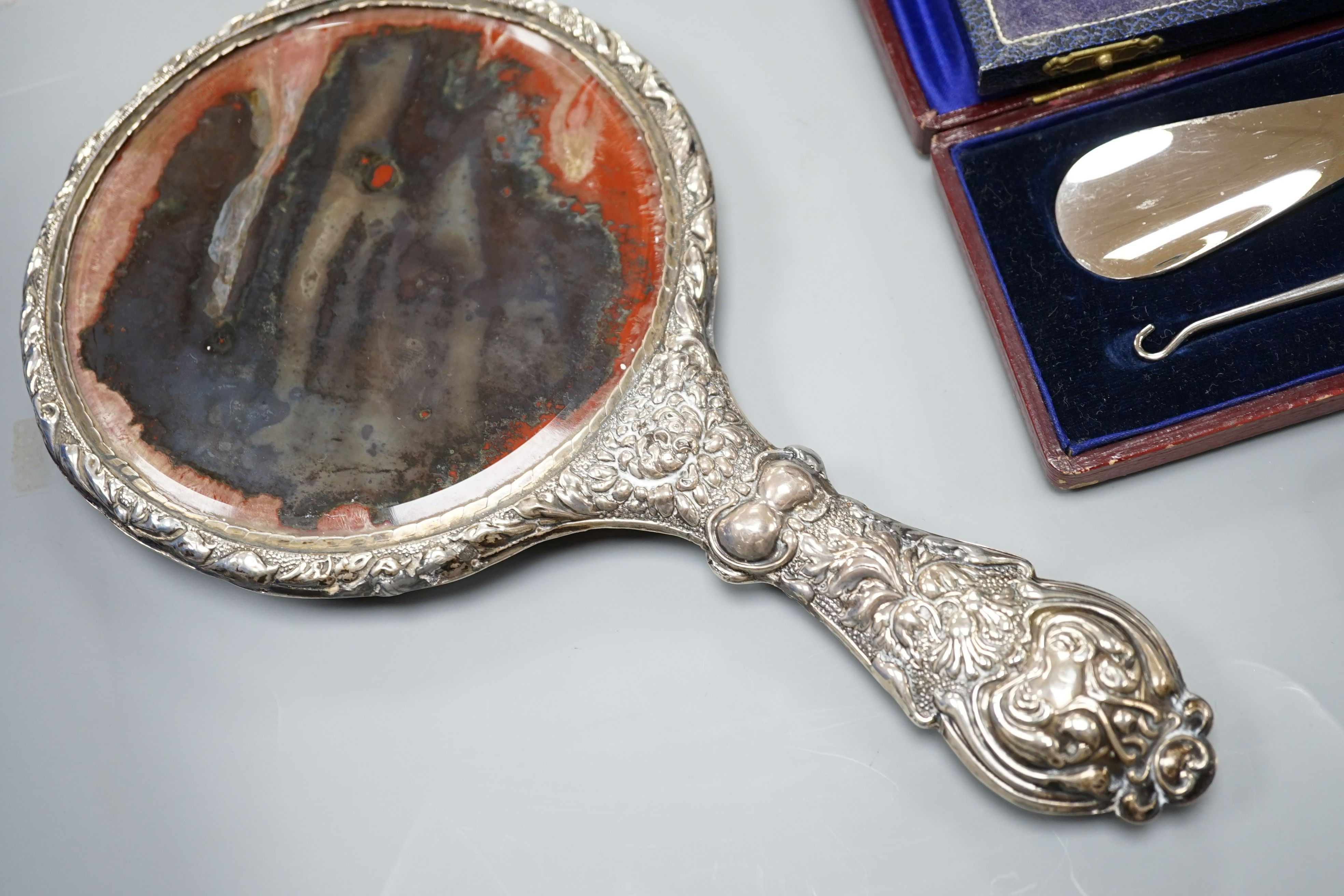 A group of small silver to include two vesta cases, a hand mirror, paste pin and a cased button hook and shoehorn.
